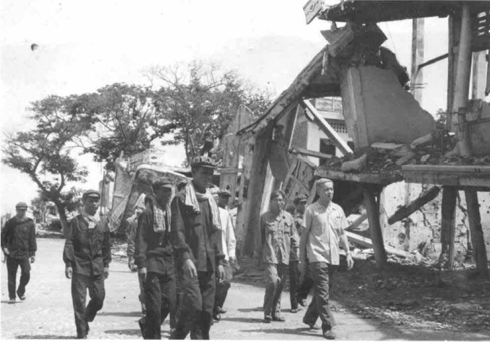 Photograph depicting KR Cadres inspecting a destroyed building