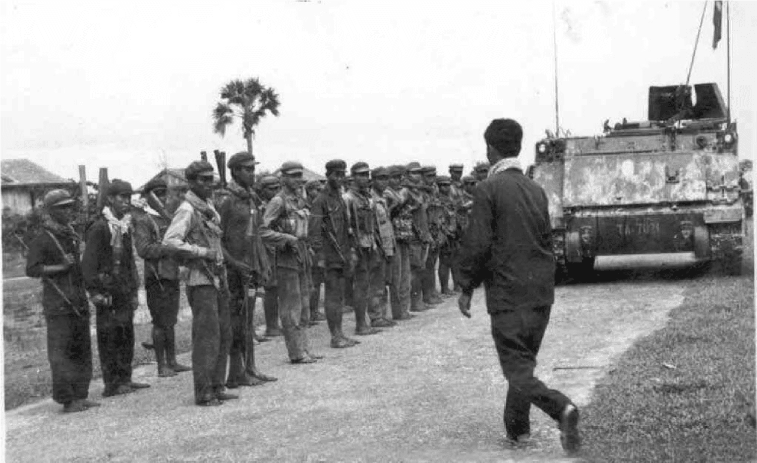 Photograph depicting KR Soldiers standing in formation with APC